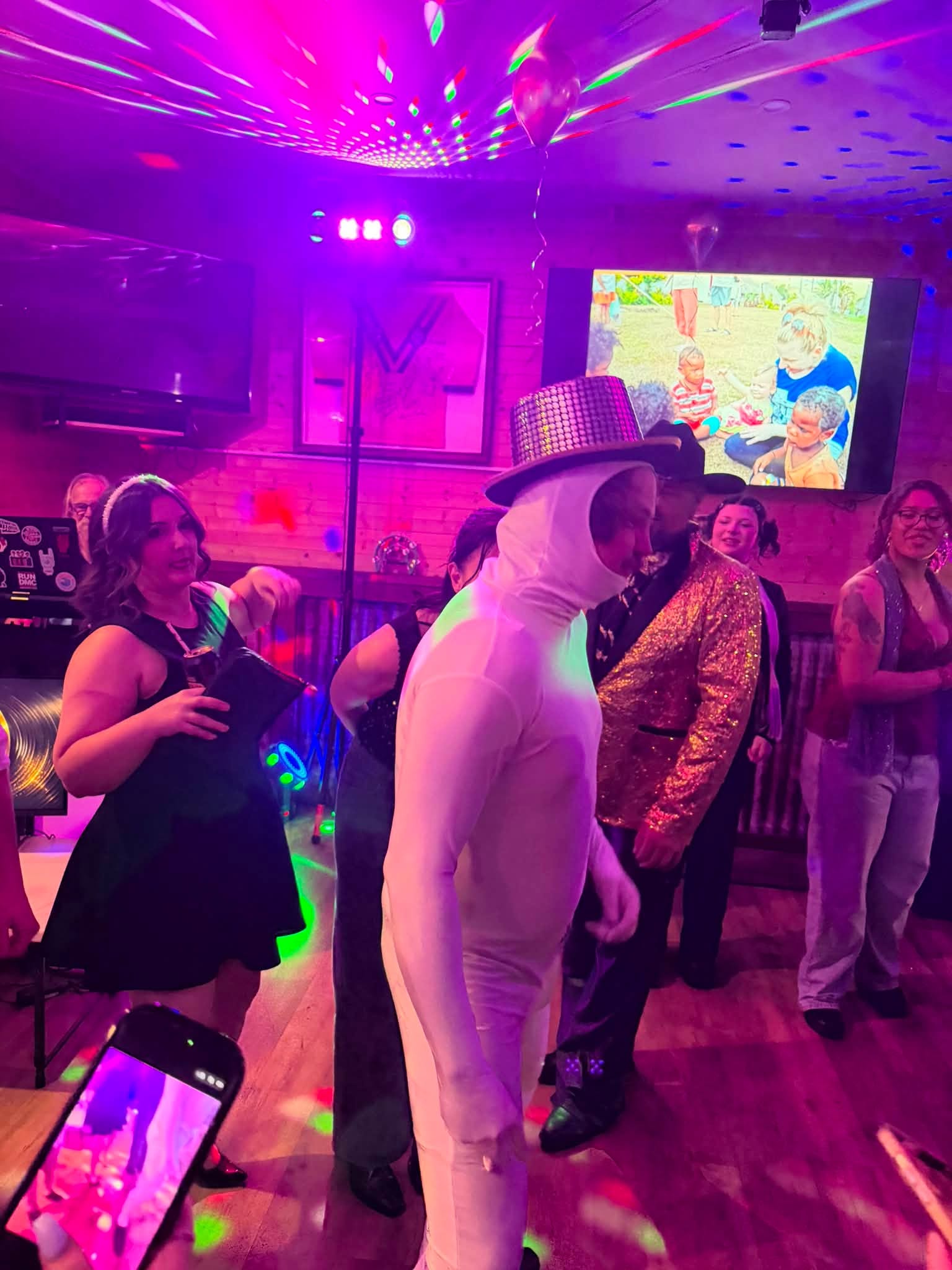 Guests dancing under DJ lighting